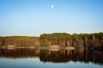 Piękne późne popołudnie nad jeziorem w Kobylej Górze z księżycem na czystym niebie. © Piotr
