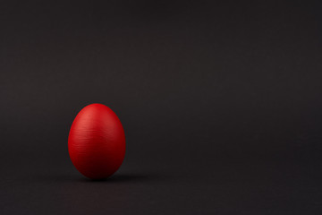 Colored red easter egg on bright black background