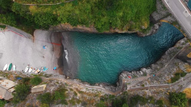Aerial top down view of Fiordo di furore beach. Incredible beauty panorama of a paradise. The rocky seashore of southern Italy. Sunny summer day. Car ride on stone bridge and clear water. Amalfi coast