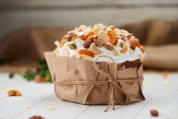 Easter cake decorated by nuts and dried fruits on white wooden background, Traditional Kulich, Paska  ready for celebration