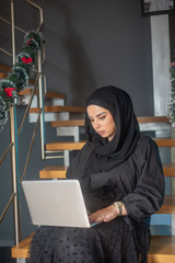 Beautiful two girls with hijab hanging out, typing on laptop, learining about photography and study