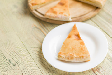 Pie with cheese, khachapuri on a wooden background.