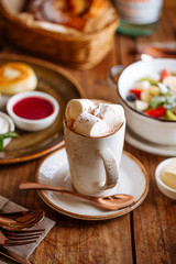Coffee with marshmallows on a laid table, breakfast, side view, vertical