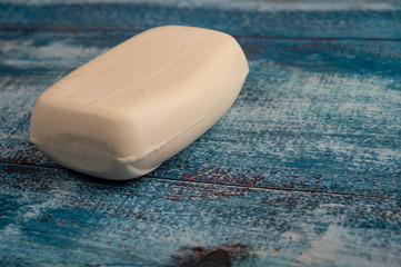 A piece of toilet soap on a wooden background. Close up. Hand washing is a prevention of COVID-19 infection.