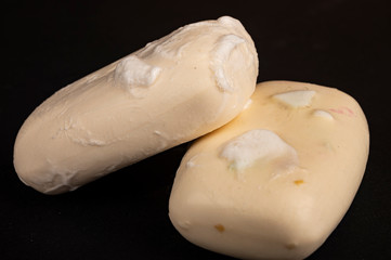 Two pieces of toilet soap on a black background. Close up. Hand washing is a prevention of COVID-19...