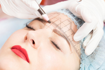 Obraz na płótnie Canvas Microblading eyebrow tattoo procedure in a beauty salon for women.