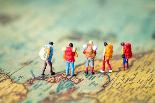 Miniature people: Group of backpacker on vintage world map using as business trip traveler adviser agency or explorer on earth background concept. - Powered by Adobe