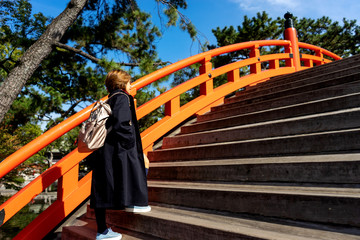 Fototapeta na wymiar Tourist woman walking on the orange bridge