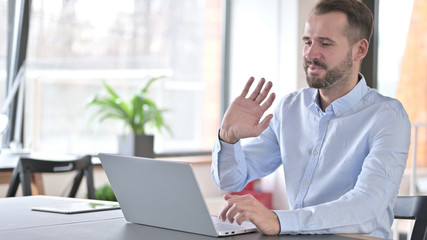 Video Chat on Laptop by Young Man in Office