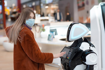 Young woman shopper and robot adviser in the store