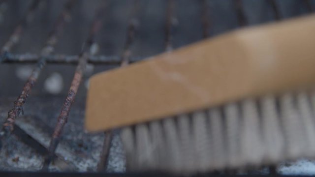 Scrubbing barbecue roster with a steel brush - extreme close