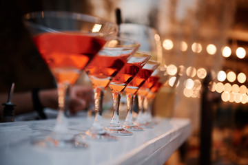 Glasses with alcohol on the table with blurred lights in the background.