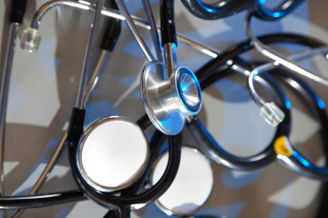 Closeup on stethoscope on a plan background with blue highlight..