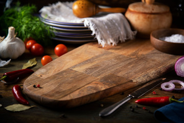 
Cutting board, plates and vegetables on a wooden table