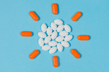 Different pills on a blue background. health and medicine. Sun