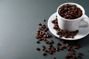 White cup of coffee with grains on a dark background