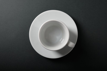 White cup for coffee on a dark background, top view