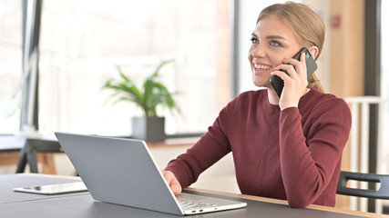Young Woman Talking on Smartphone in Office