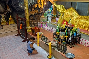 Kanchanaburi, Thailand - August 14, 2019 :A woman praying in Wat Tham Khao temple also known as Tiger Cave Temple.