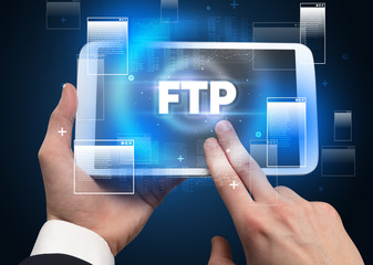 Close-up of a hand holding tablet with FTP abbreviation, modern technology concept