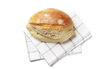loaf of homemade bread on a towel isolated on white background