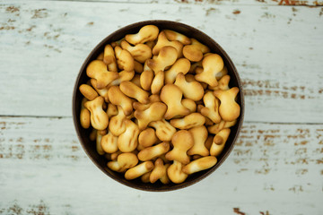 Fish cookies in a bowl over wooden background.