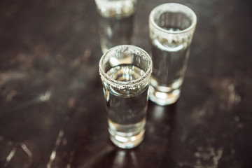 Tequila shots on the dark rustic background. Selective focus. Shallow depth of field.
