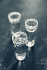 Tequila shots on the dark rustic background. Selective focus. Shallow depth of field.

