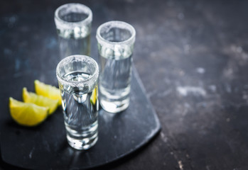 Tequila shots on the dark rustic background. Selective focus. Shallow depth of field.
