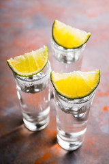 Tequila shots on the dark rustic background. Selective focus. Shallow depth of field.
