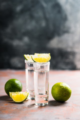 Tequila shots on the dark rustic background. Selective focus. Shallow depth of field.

