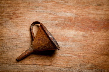 Old vintage metal funnel for filling liquid of the last century extracted from a chest in the workshop of grandfather. Background for craftsmanship and manual labor.