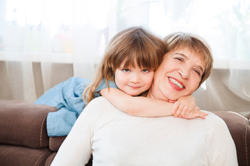 Happy middle-aged mature grandma and  little preschooler granddaughter having fun playing at home. Quality Time. Family having fun playing at home. stay home concept