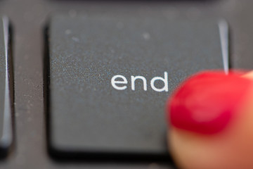 finger pushing the end button on a laptop computer key board. The end. the end is near. Stopping, putting an end to something. Finishing, final. to cease. It's over.