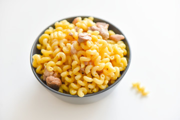 boiled macaroni with meat on a plate on a white background