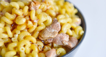 boiled macaroni with meat on a plate on a white background