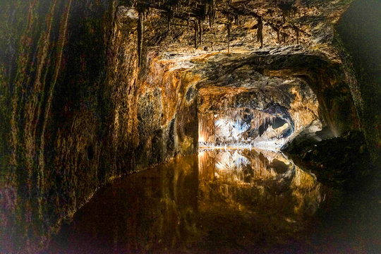 Urlaub in Deutschland: Saalfelder Feengrotten - Spiegelung von Tropfsteinh&ouml;hle mit Lichteffekten in glatter Wasseroberfl&auml;che
