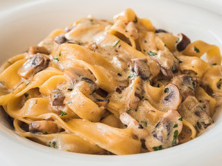 homemade pasta with champignons and cream sauce on a plate