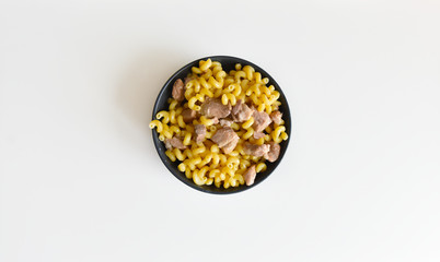 boiled macaroni with meat on a plate on a white background