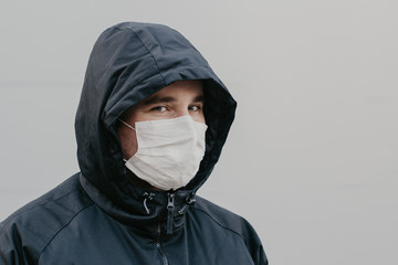 man wearing mask on a background of neutral background, coronavirus, illness, infection, quarantine, medical mask, place for text, copyspace