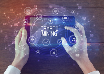 Close-up of a tablet with CRYPTO MINING inscription, innovative technology concept