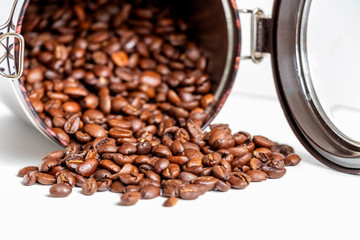 close up of grains of black coffee inside a coffee bottle isolated on white background with copy space.
