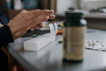 Senior arranges medicines for each day of week