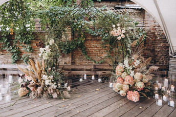Wedding decorations. The wedding ceremony area in the loft against a brick wall is decorated with...