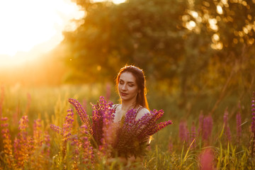 Flowers and the woman palm in the field. Lit evening sun