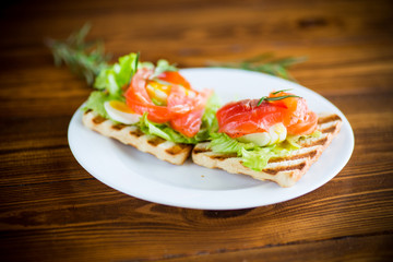 fried bread toast with salad leaves and salted red fish