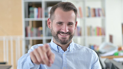 Fototapeta premium Portrait of Attractive Young Man Pointing with Finger