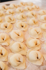 Procesul pas cu pas al femeii care face găluște de casă, ravioli sau pelmeni cu umplutură tocată
