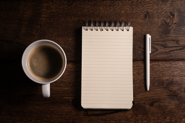 Obraz na płótnie Canvas Zdjęcie notesu z długopisem i kawy na drewnianym stole