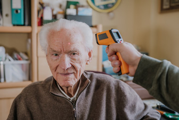 Old man measured temperature with thermometer
